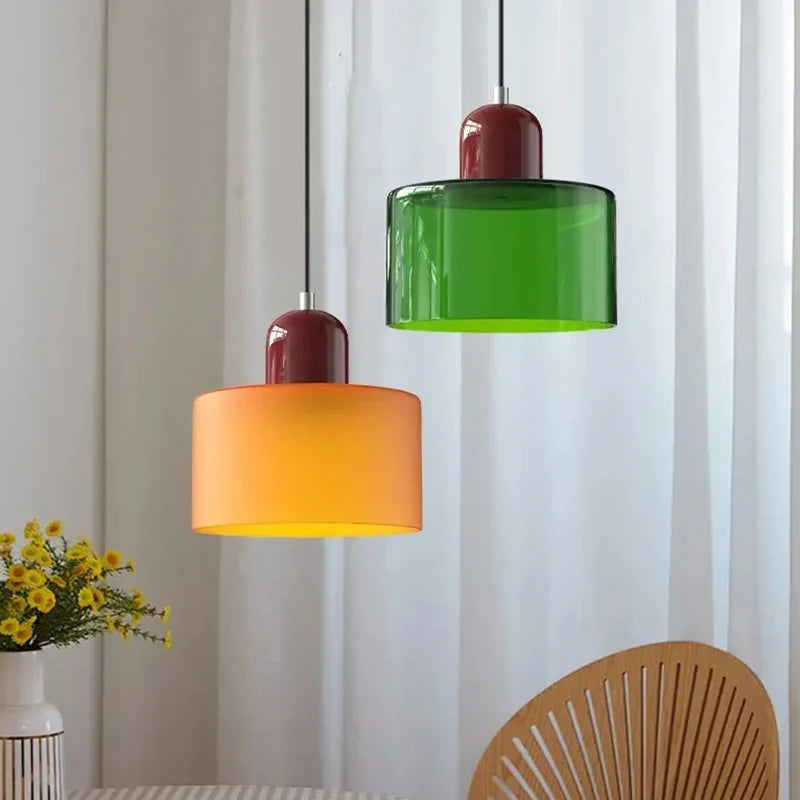Orange and green Mira pendants hanging beside white curtains