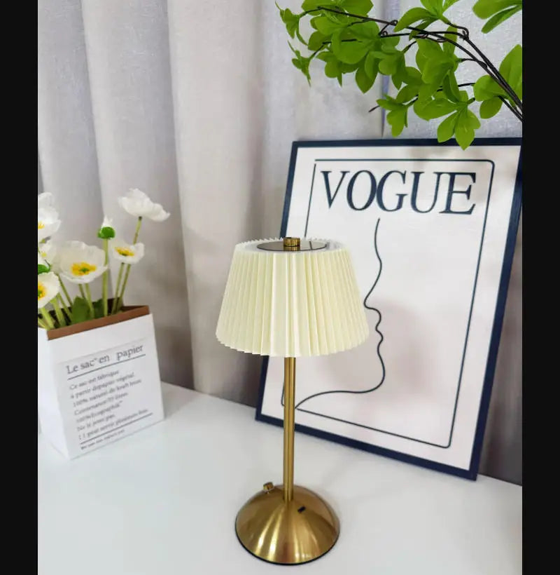 Cream Elara pleated lamp styled beside books and flowers