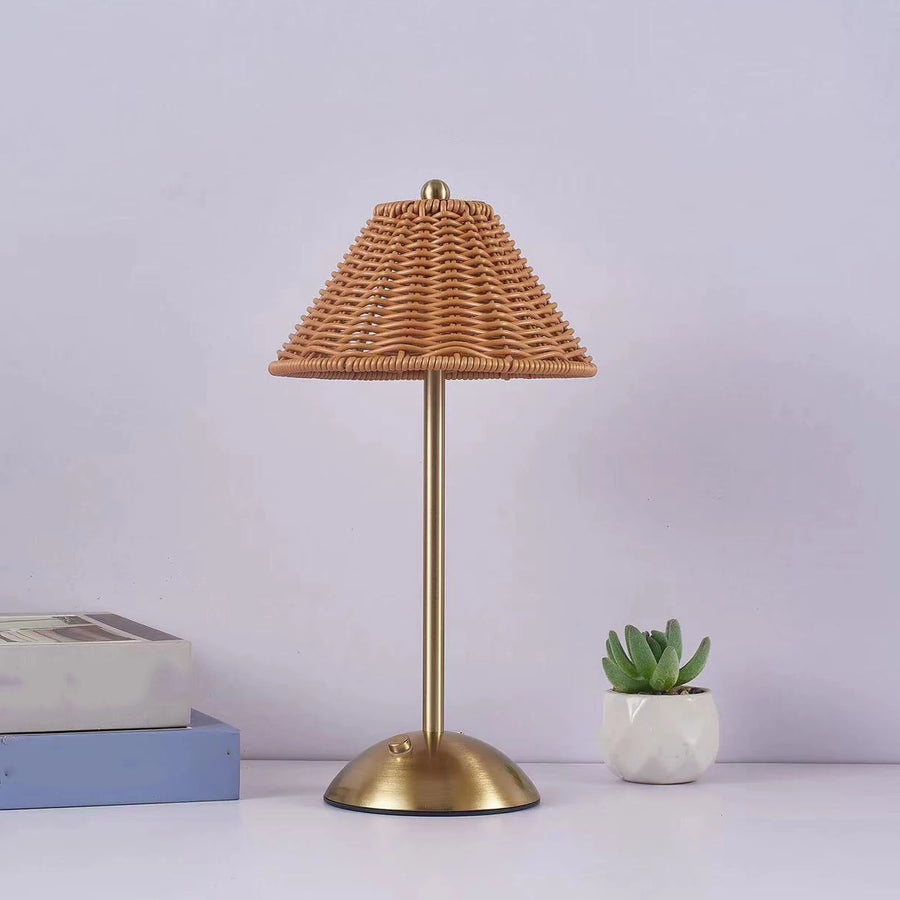 Gold Riva cordless lamp with a woven shade on a white surface