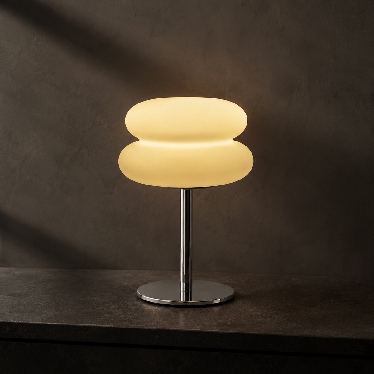 Ember Halo frosted table lamp on dark stone at dusk