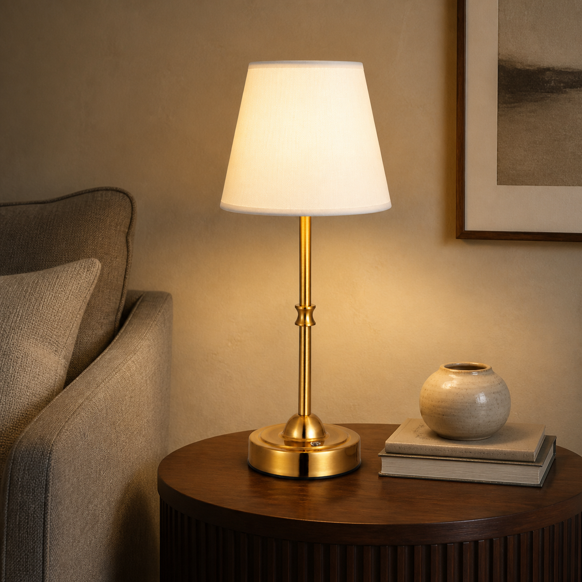 Gold Laurent table lamp glowing on a round side table