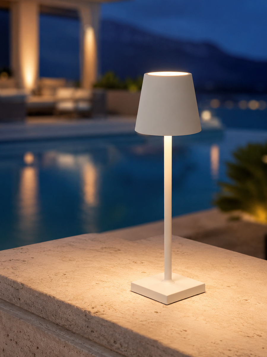 Ember Marin water-resistant cordless lamp on a travertine ledge at dusk