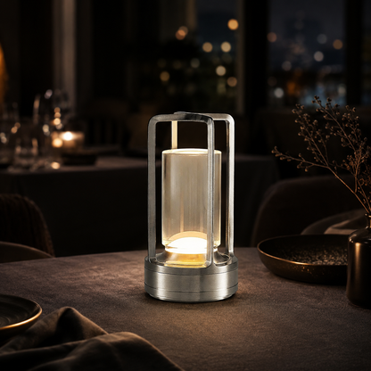 Ember Marlow cordless lamp in silver lit on a dark restaurant table at night