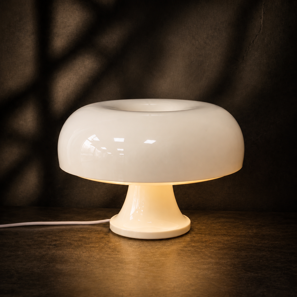 White Oslo mushroom table lamp glowing against a dark backdrop