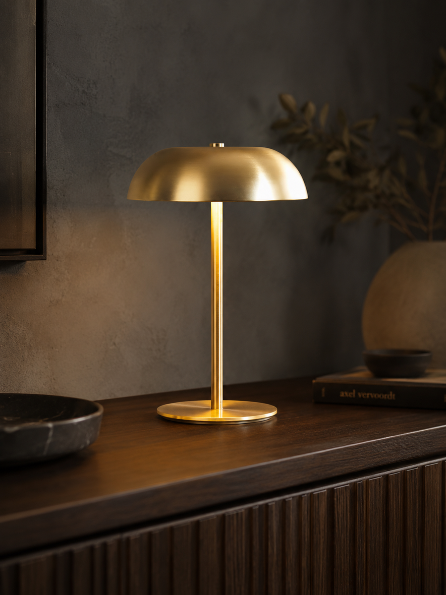 Ember Sol brushed-metal dome lamp glowing on a walnut console