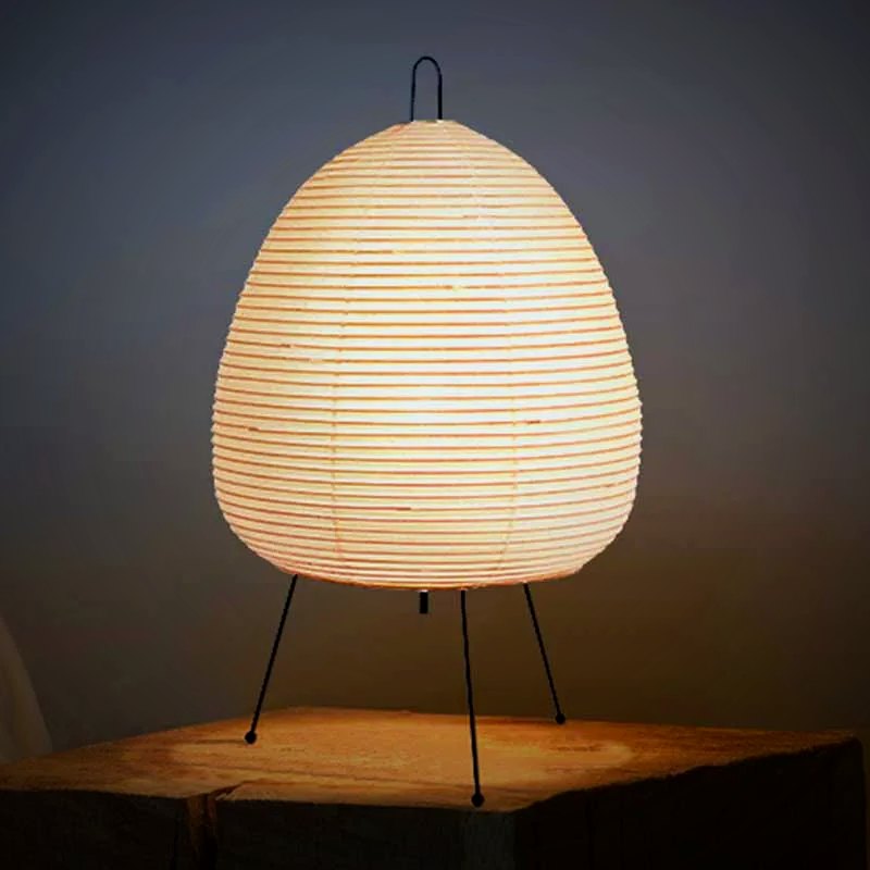 Ember Yumi paper lantern tripod table lamp lit on a wood block